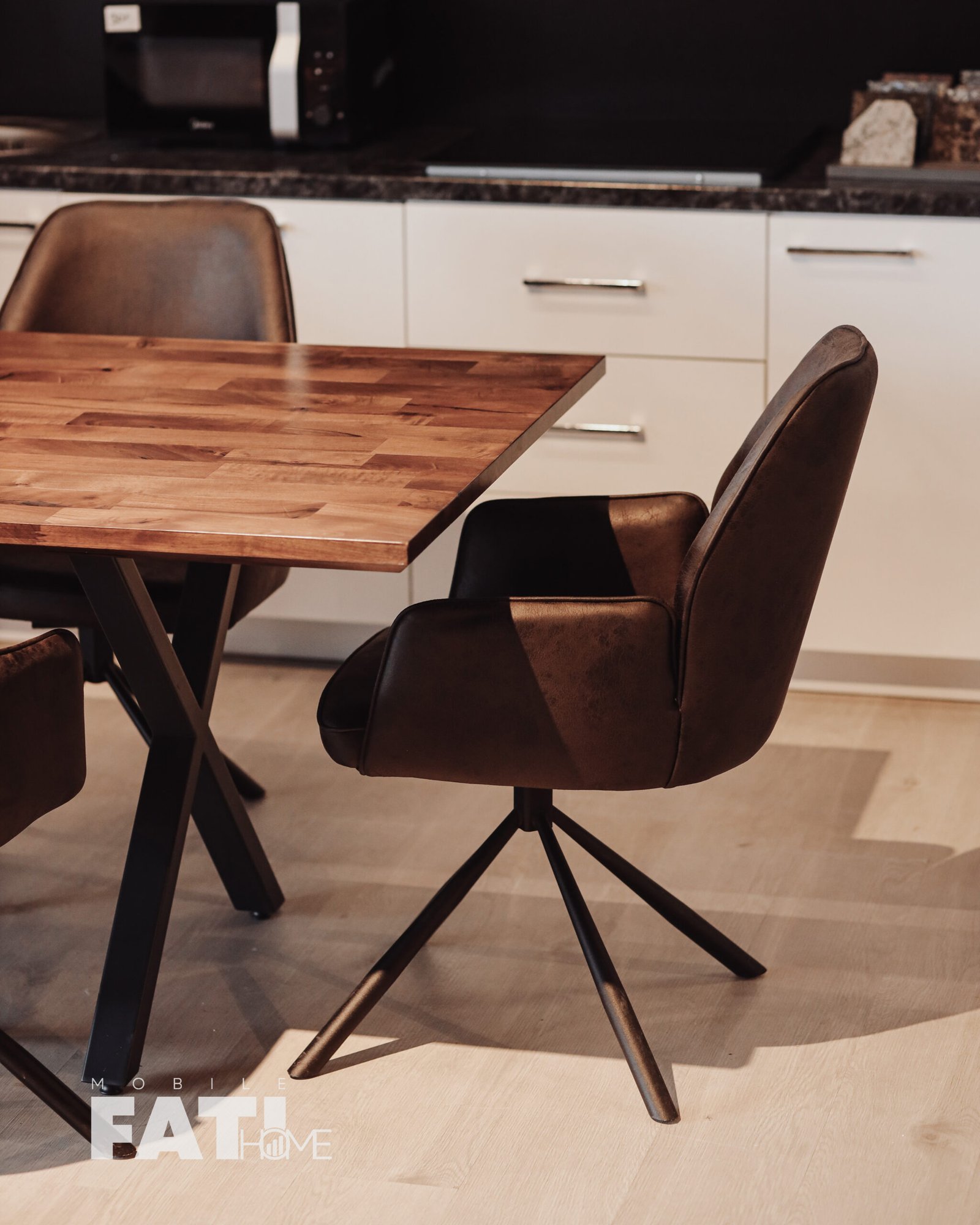 Detaj anësor i karriges “Arden” me tapiceri kafe dhe bazë metalike të zezë.